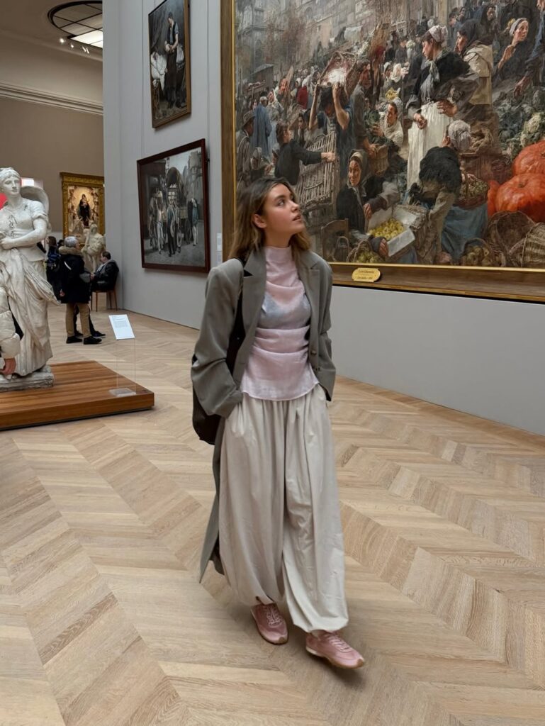Mulher de pele clara, com look de frio e tênis de cetim