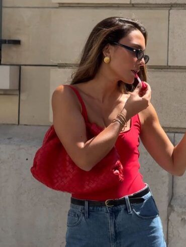 Look de trabalho com bermuda jeans e blusa vermelho com decote quadrado em mulher branca e magra