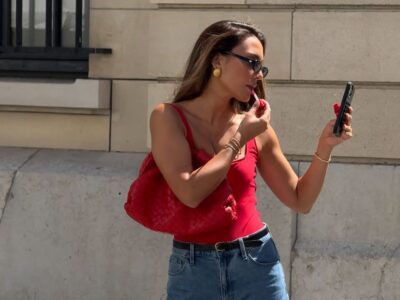 Look de trabalho com bermuda jeans e blusa vermelho com decote quadrado em mulher branca e magra