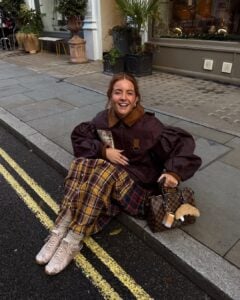 Mulher de pele clara, com look de frio e tênis de cetim