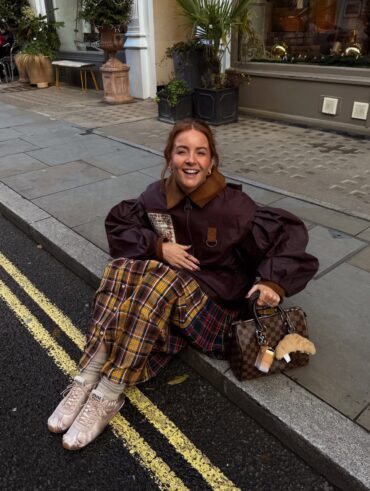 Mulher de pele clara, com look de frio e tênis de cetim