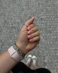 Mão de pele clara, com acessórios e unhas naturais