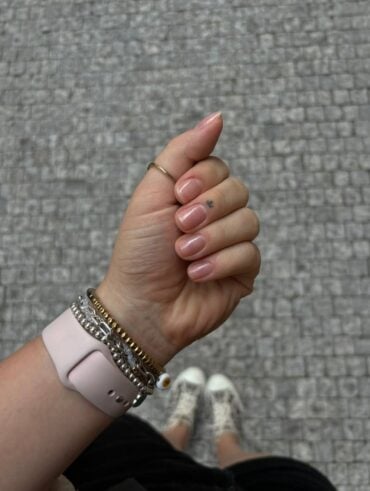 Mão de pele clara, com acessórios e unhas naturais