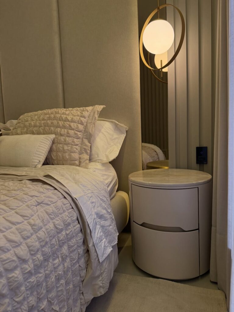 Quarto com mesa de cabeceira arredondada com gavetas e pendente acima