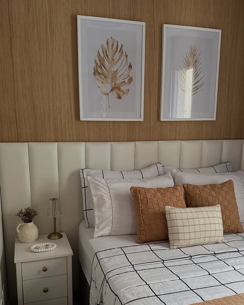 Quarto aconchegante com cabeceira estofada modular e quadros delicados acima