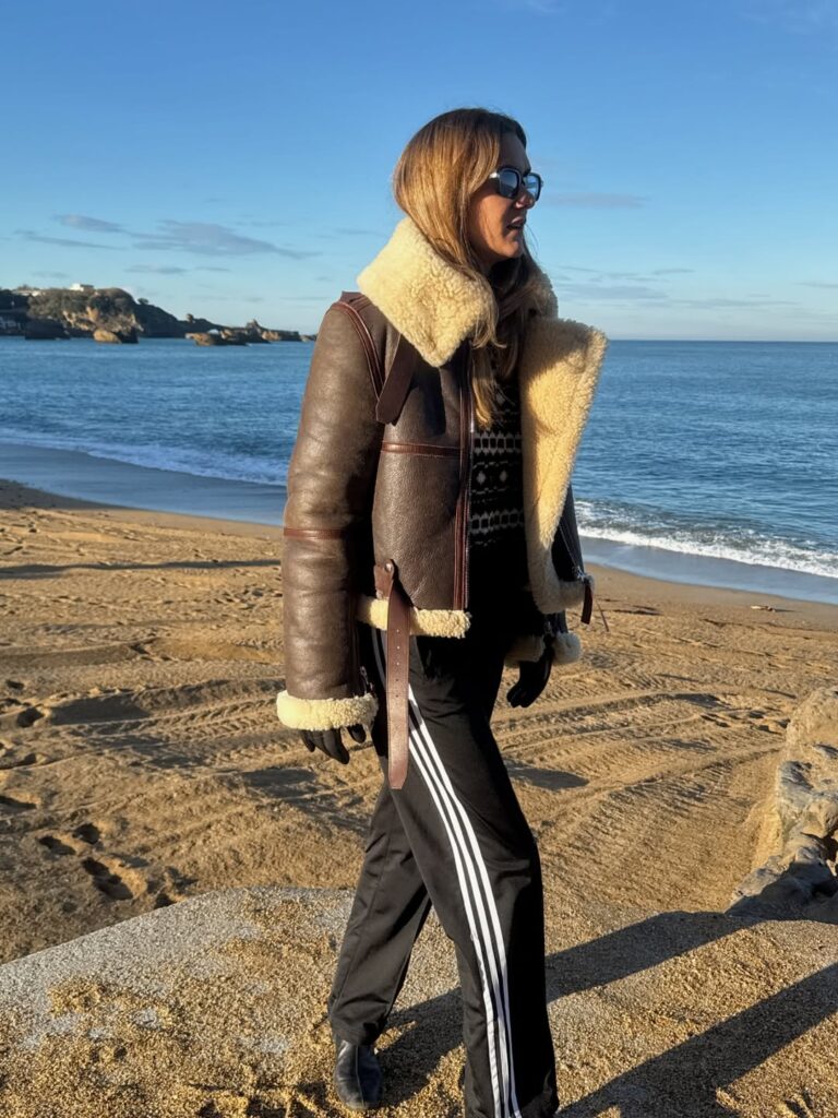 Mulher de pele clara, com casaco e calça de treino