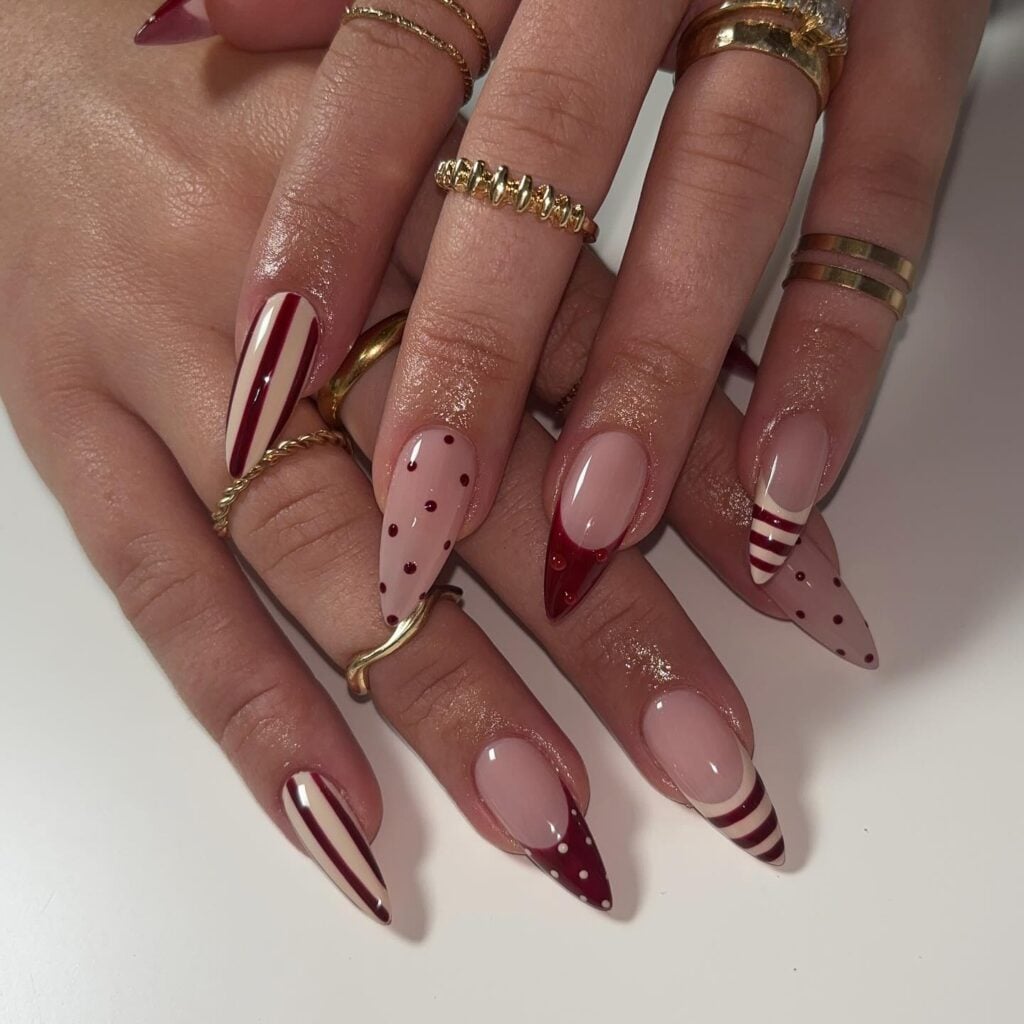 Unhas com listras e francesinhas decoradas em mão de pele branca