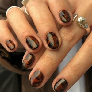 Unhas de casco de tartaruga com nail art com esmalte preto e marrom