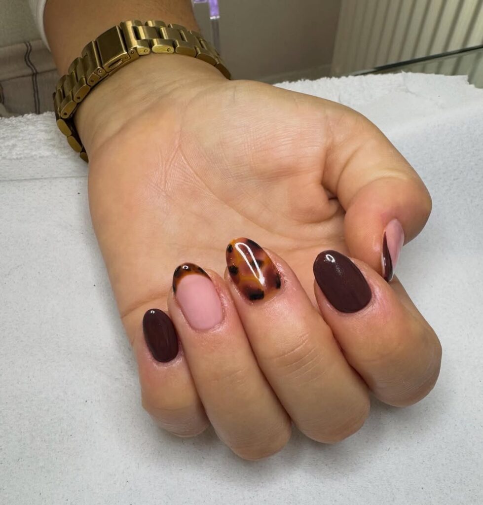 Unhas de tartaruga em mão de pele branca com francesinha e estampa de animal print