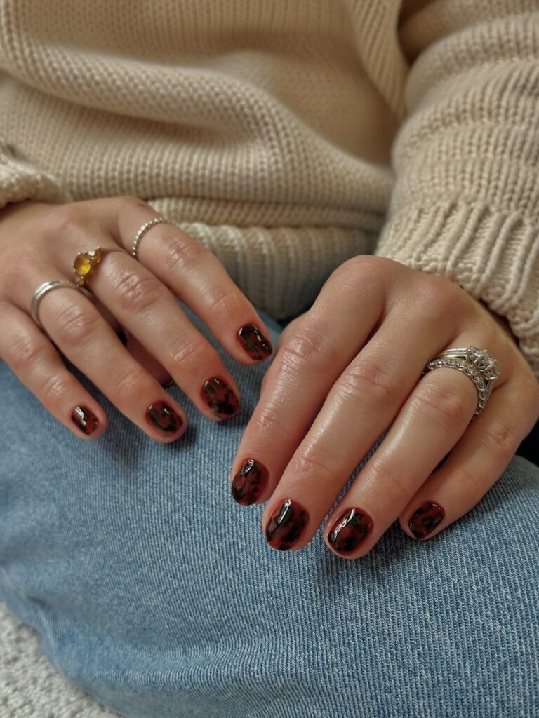 Unhas de casco de tartaruga com nail art com esmalte preto e marrom