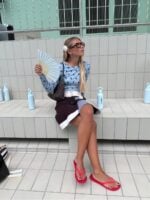 mulher jovem com blusa de manga longa, saia e chinelo de dedo vermelho