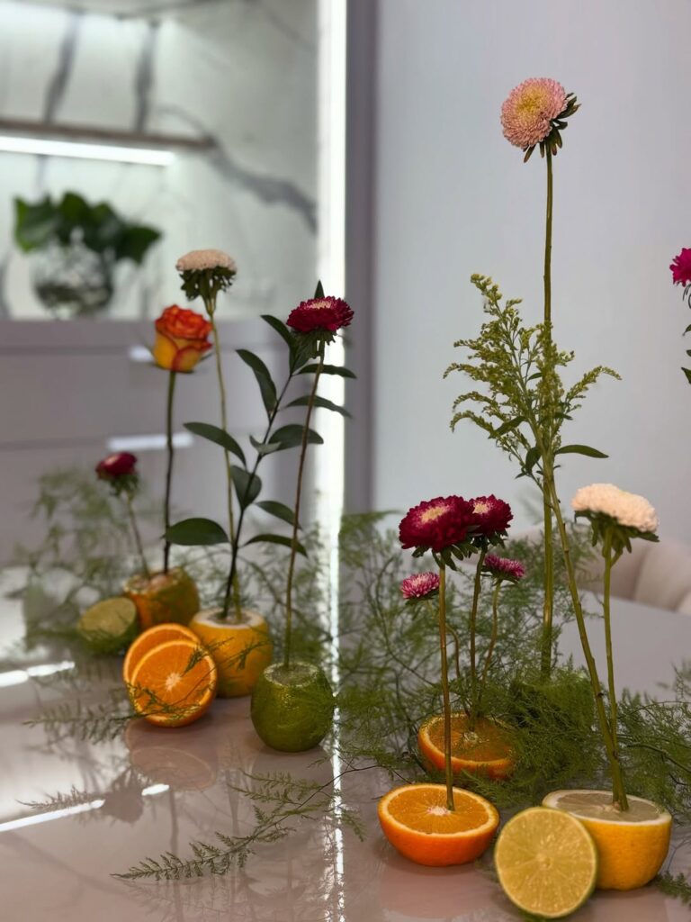 Laranjas decoradas com flores e ramos verdes