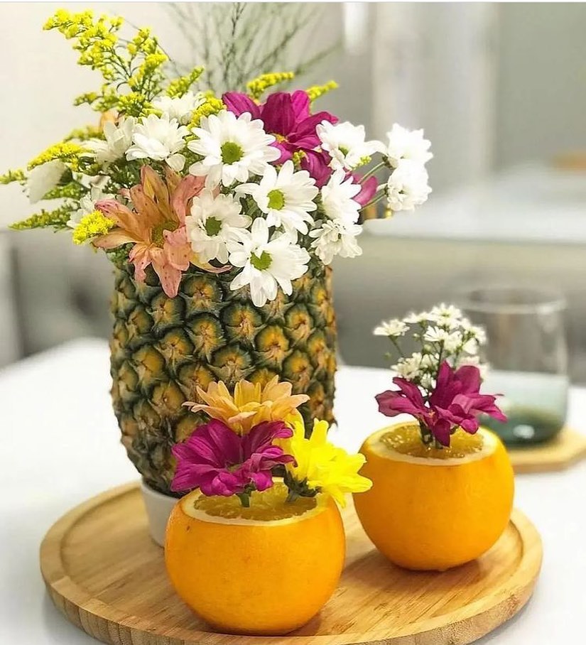 Abacaxi e laranjas decorados com flores