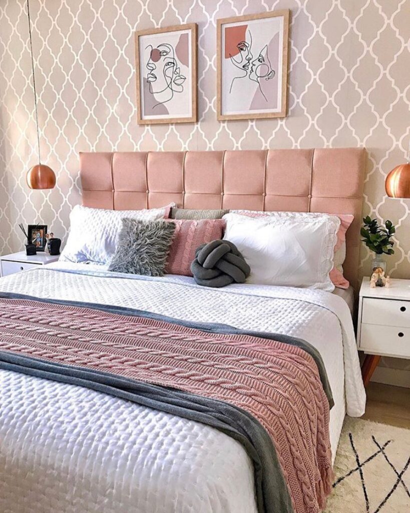 Cama com cabeceira rosa, manta de tricô rosa e almofadas variadas