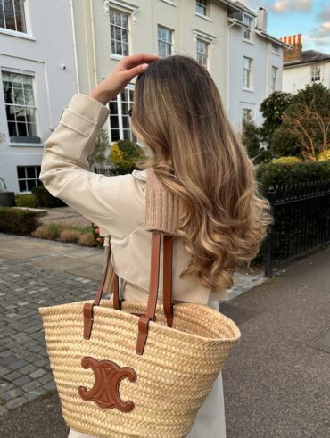 Mulher de pele clara, com casaco bege e cabelo com mechas loiras