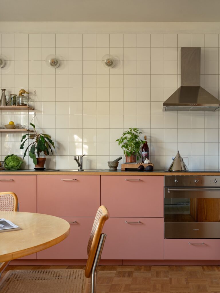 Cozinha com móvel rosa e revestimento quadrado