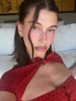 Hailey Bieber, com cabelo escuro e roupa de poá