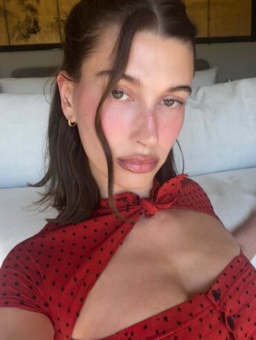 Hailey Bieber, com cabelo escuro e roupa de poá