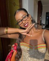 Mulher de pele preta, com cabelo semi preso e maquiagem leve