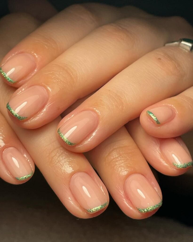 Mãos de pele clara, com unhas curtas com francesinha brilhosa
