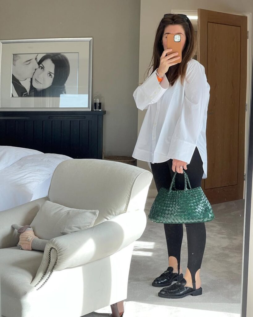 Mulher de pele clara, com camisa branca e calça legging com pézinho