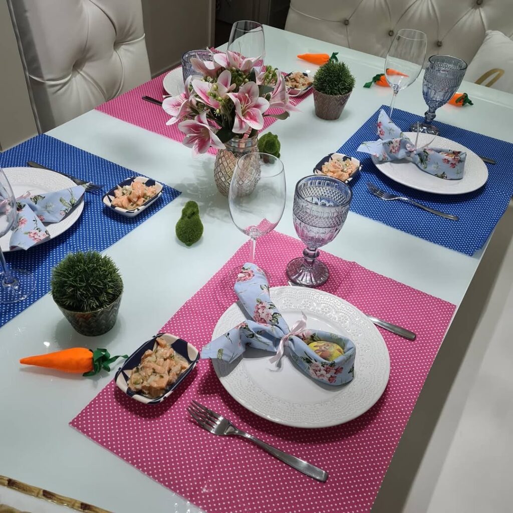 Mesa de páscoa colorida e divertida com jogos americanos em rosa e azul