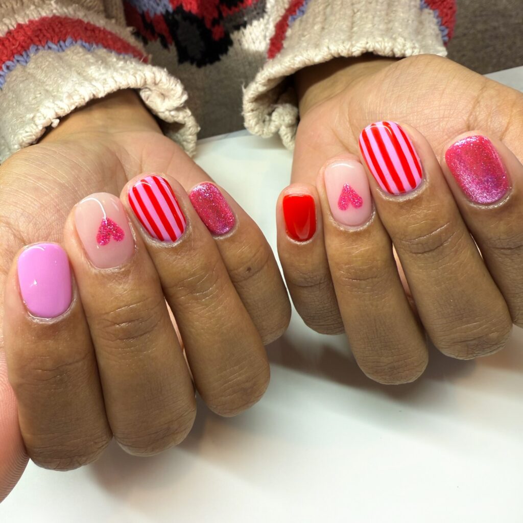 Unha de gel em mão de pele negra com nail art com listras