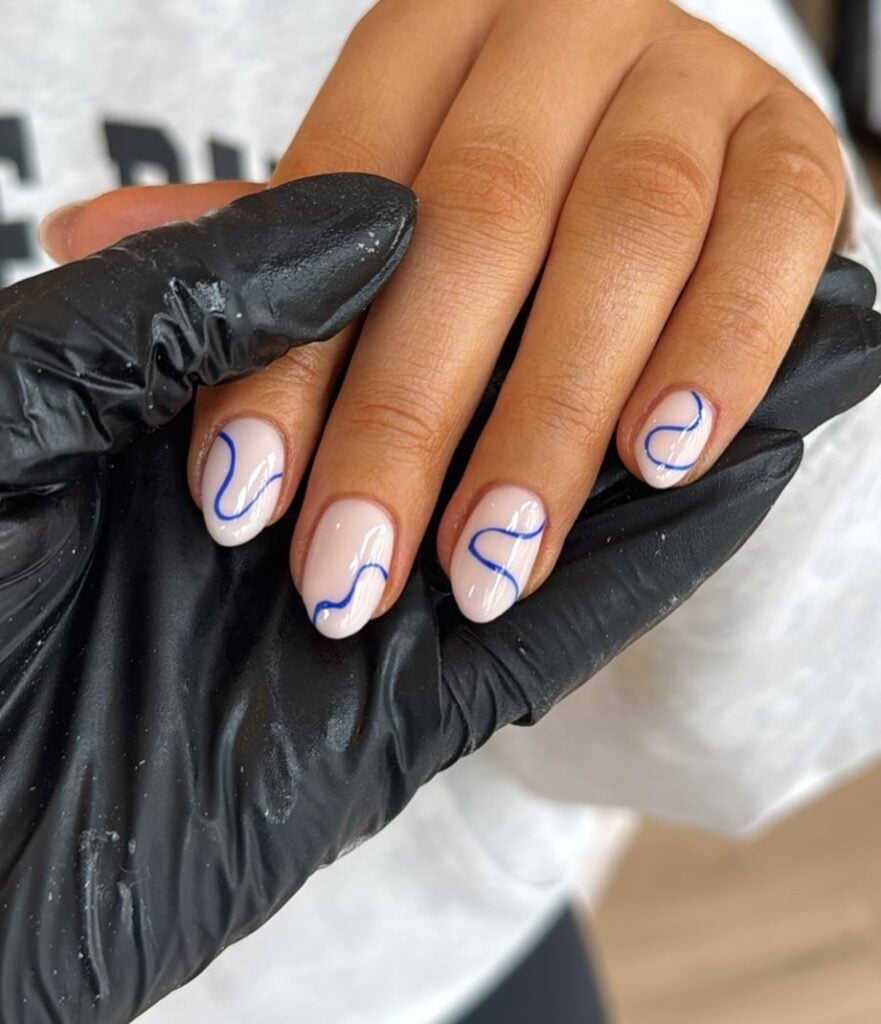 Unha de gel em mão de pele branca com nail art squiggle nails