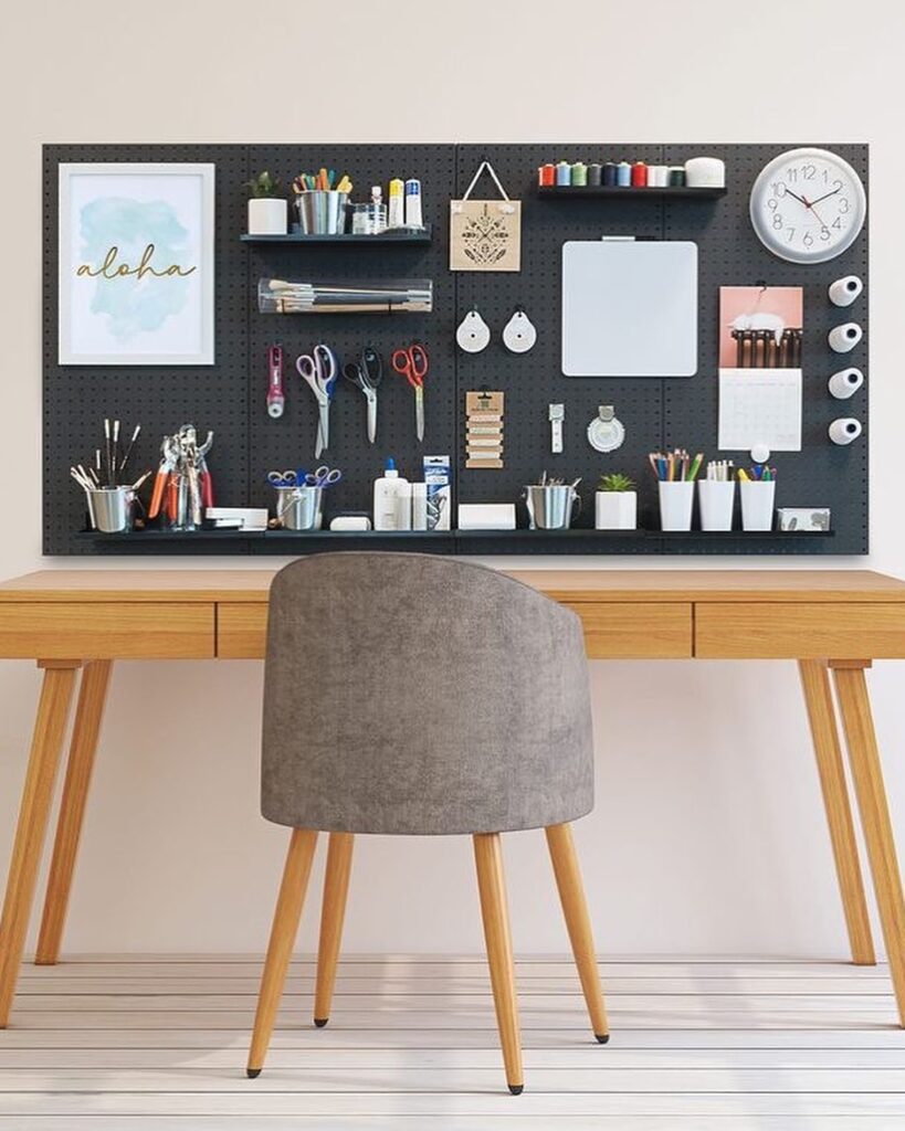 Mesa de madeira e poltrona, pegboard preto na parede com intes de home office