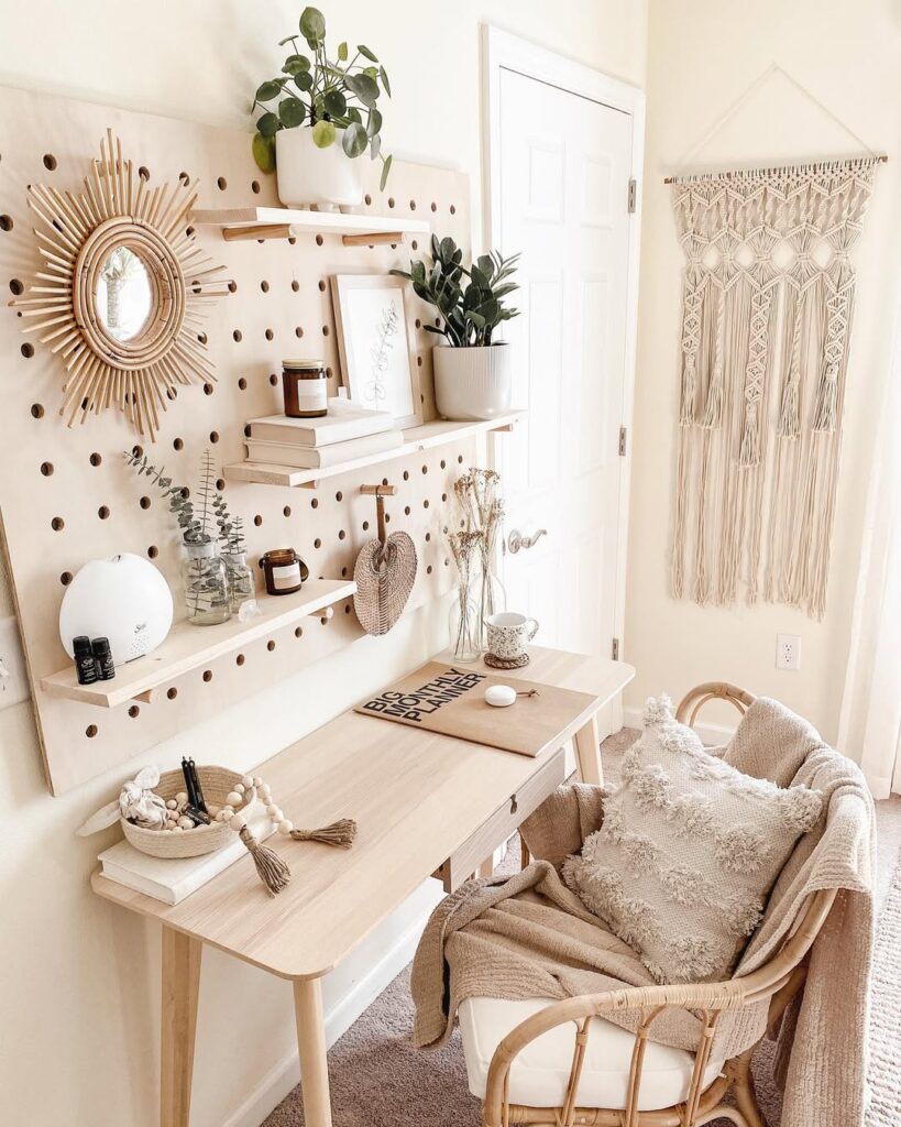 Home office em tons neutros com pegboard, espelho, prateleiras, plantas e outros objetos decorativos