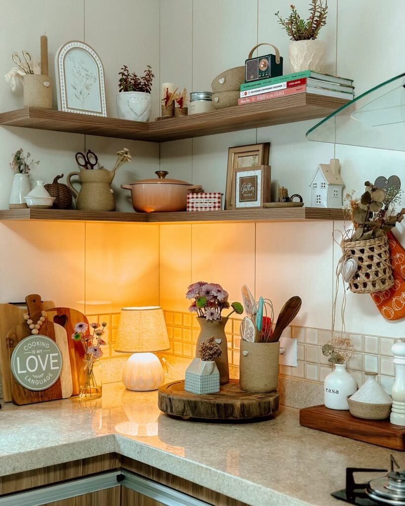 Bancada de cozinha com abajur, objetos decorativos e prateleiras com livros e quadrinhos