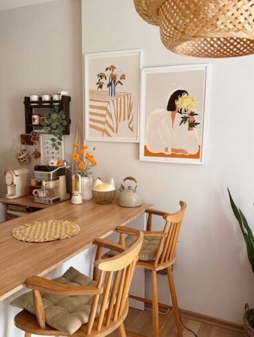 Inspiração de quadros na cozinha com imagens na mesma paleta de cores, moldura branca e mesa e cadeiras de madeira