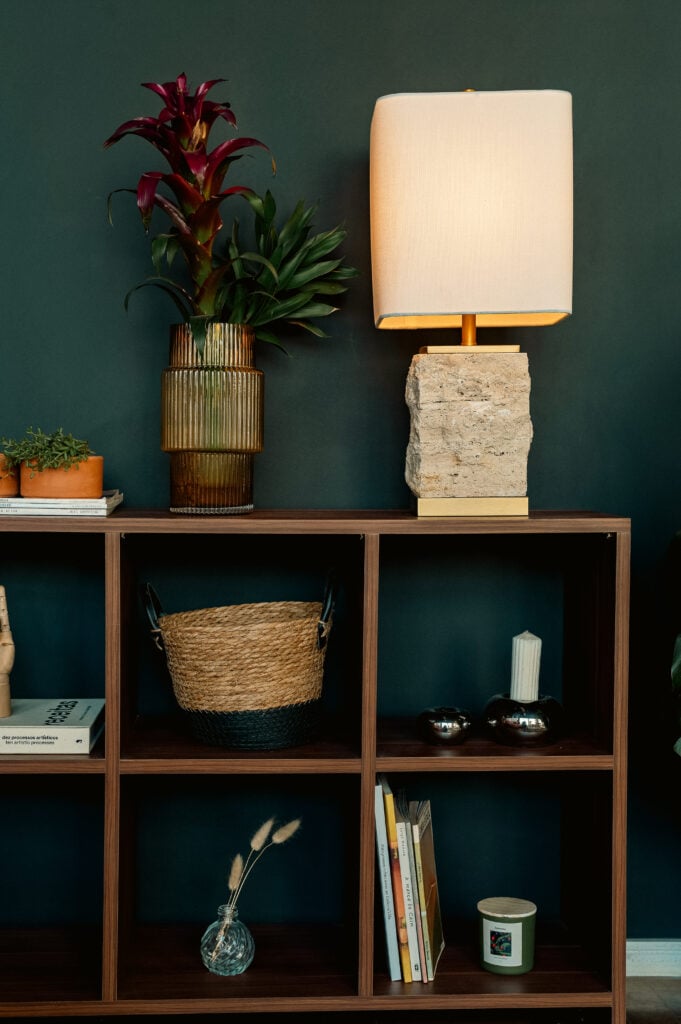 Estante com nichos, objetos decorativos e abajur com base de concreto