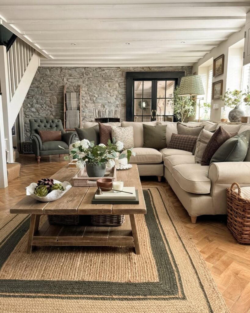 Sala de estar com sofá claro em L e almofadas, mesa de centro de madeira e tapete de fibras naturais