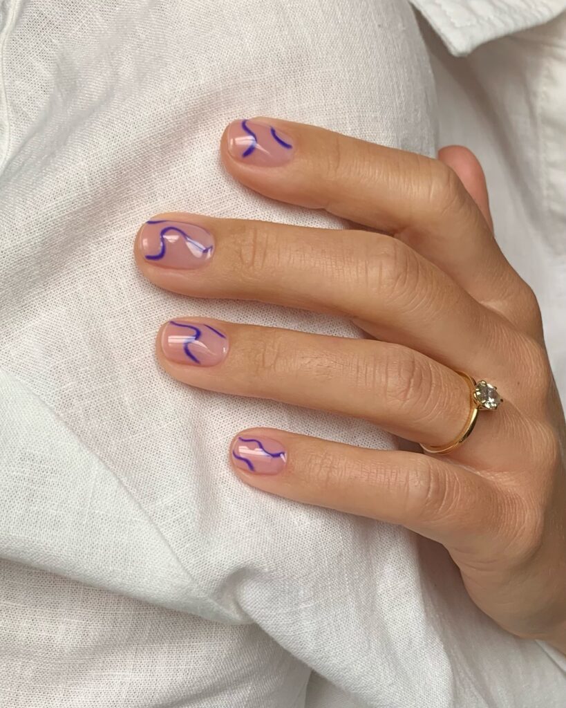 Unha de gel em mão de pele branca com nail art squiggle nails