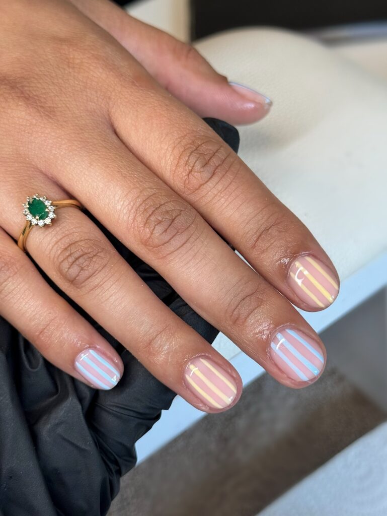 Unha de gel em mão de pele negra com nail art com listras