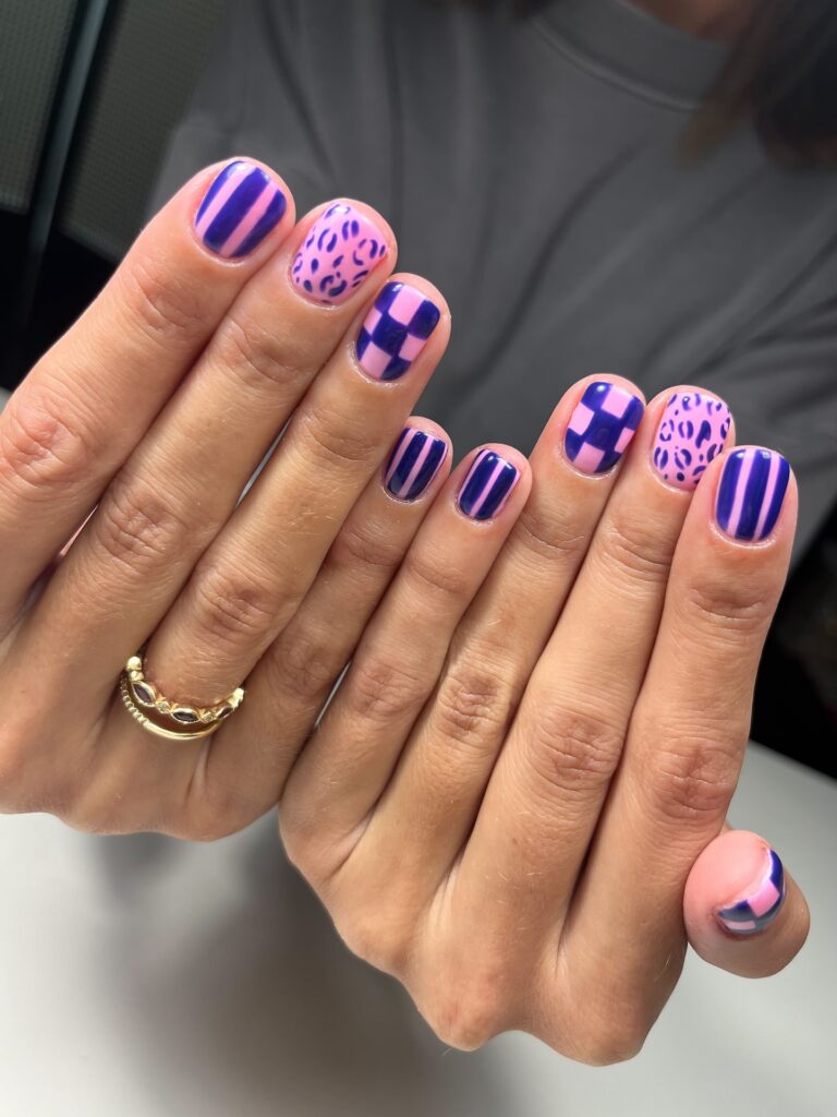 Unha de gel em mão de pele branca com nail art com listras