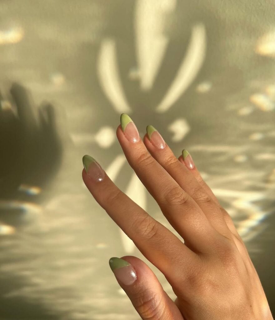 Mão de pele clara, com unha amendoada com francesinha verde-sálvia - @mad.mad.nails