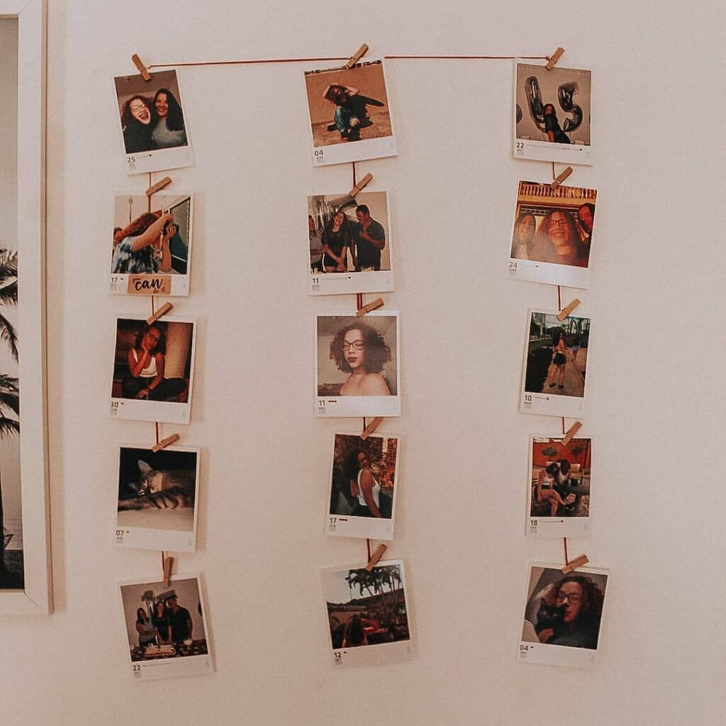 Varal de fotos polaroide em parede branca