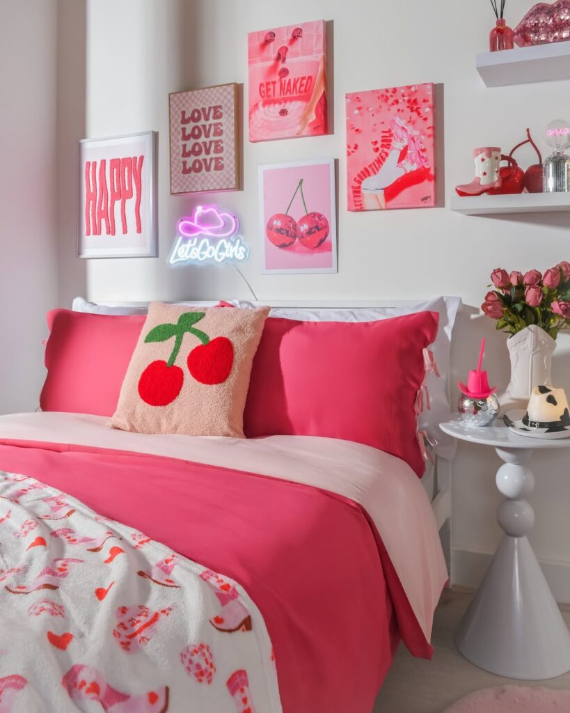 Quarto em rosa e branco com cerejas na almofada, no quadro atrás da cabeceira e no enfeite na prateleira