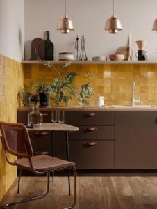 Cozinha sem armário superior, backsplash amarelo e louças aparecendo