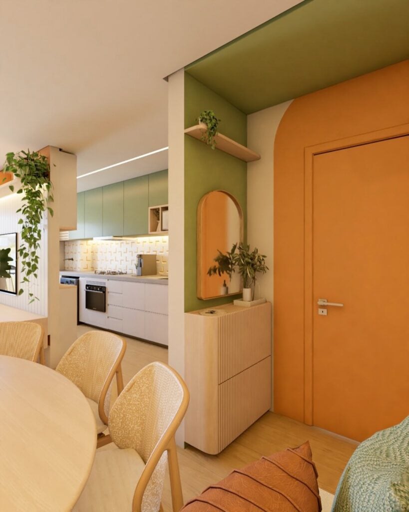 Hall de entrada com porta laranja, parede verde com aparador, planta e espelho