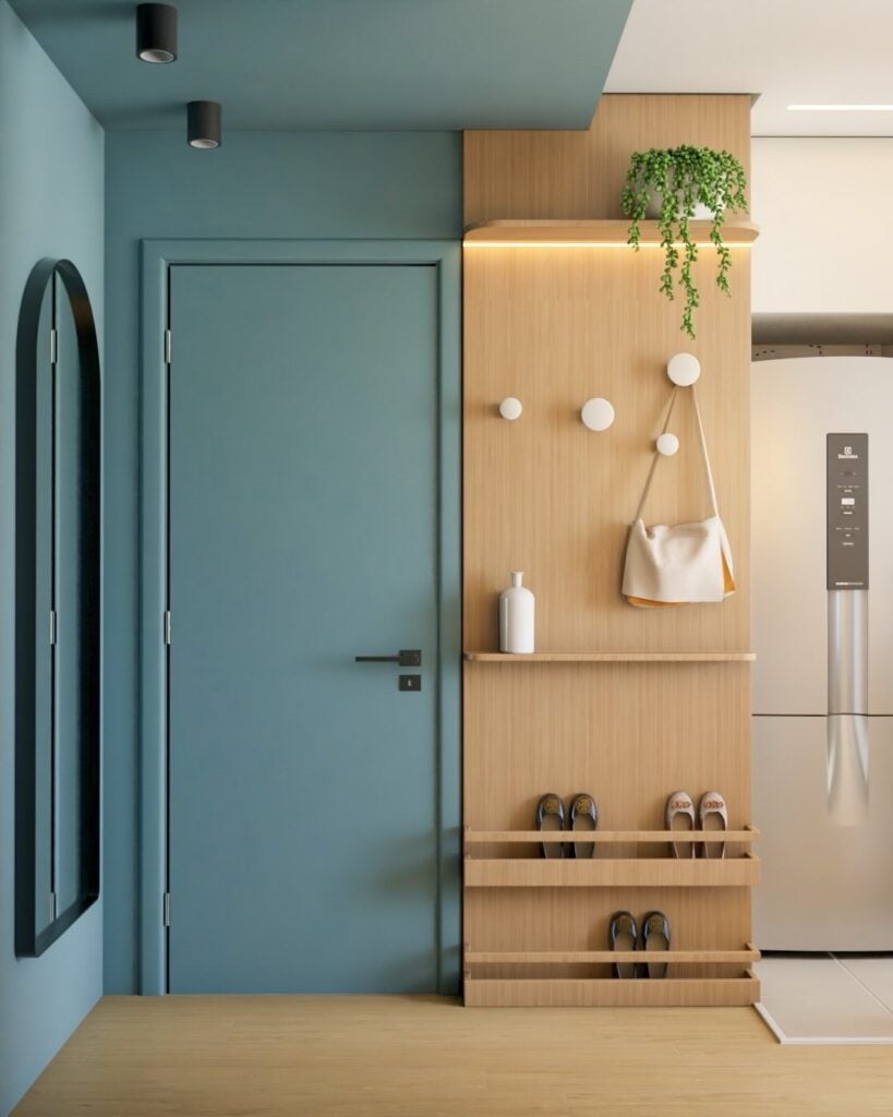 Entrada de casa azul com sapateira e suporte para bolsas em painel amadeirado