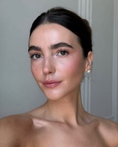 Mulher de pele clara, com cabelo preto e maquiagem clean