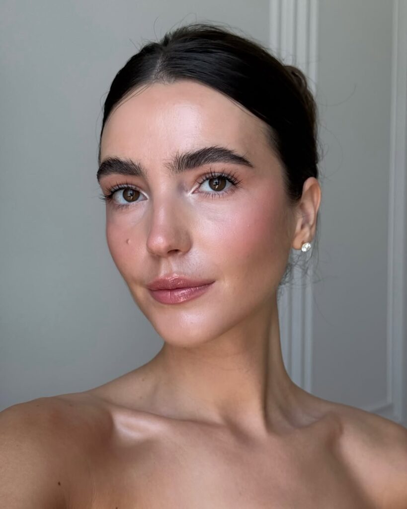 Mulher de pele clara, com cabelo preto e maquiagem clean 