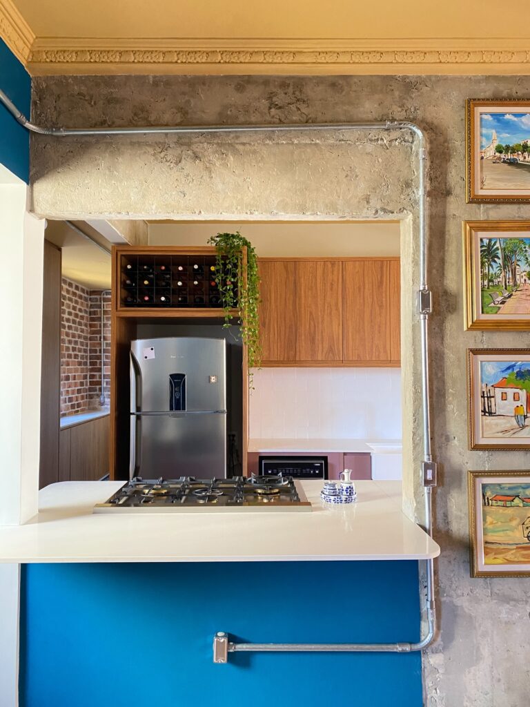 Fogão da cozinha com bancada azul e branca e geladeira de inox