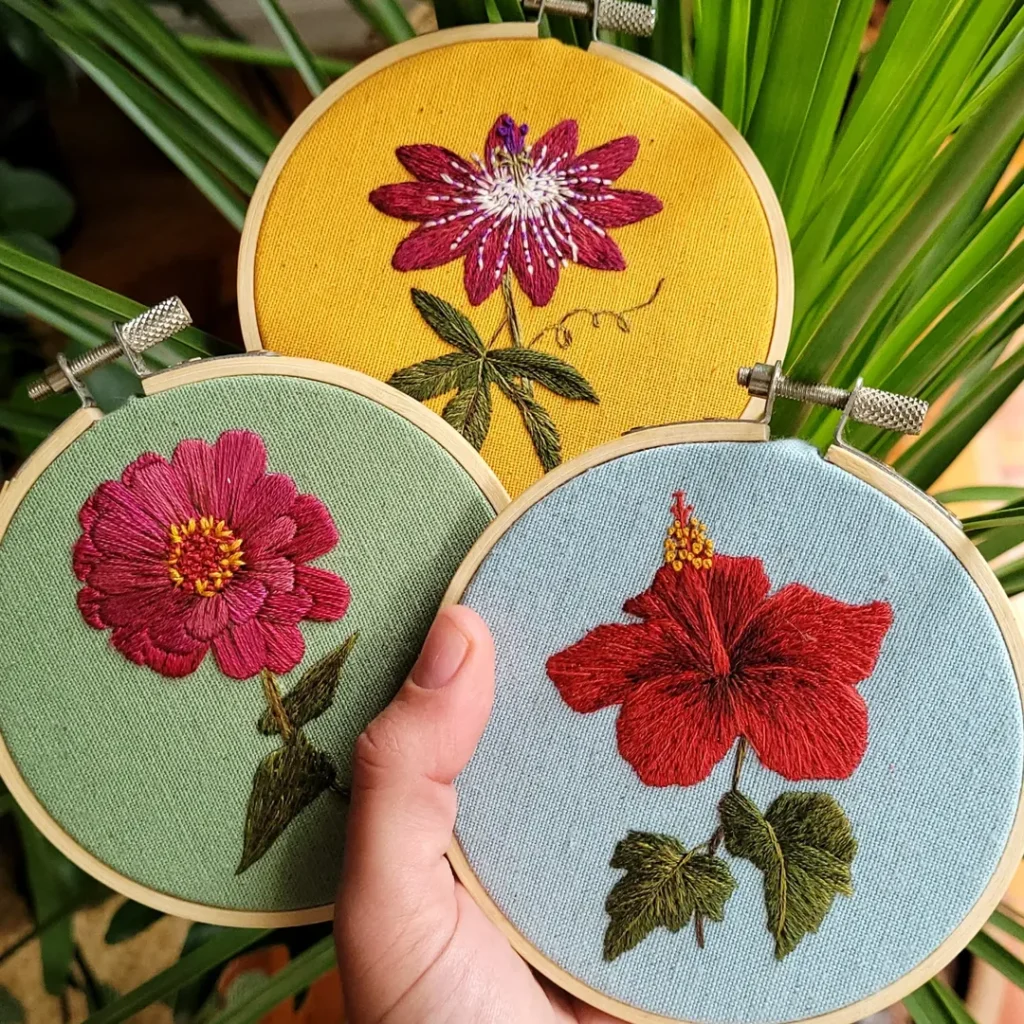 Mão segurando bordados de flores
