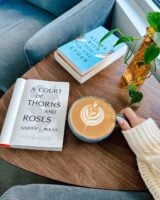 Mesa com livros e um café apoiados