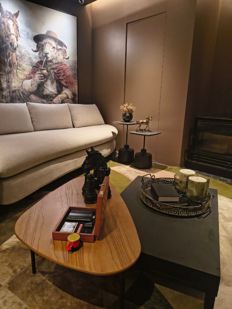 Sala de estar com sofá claro e elementos em tons terrosos no tapete e parede