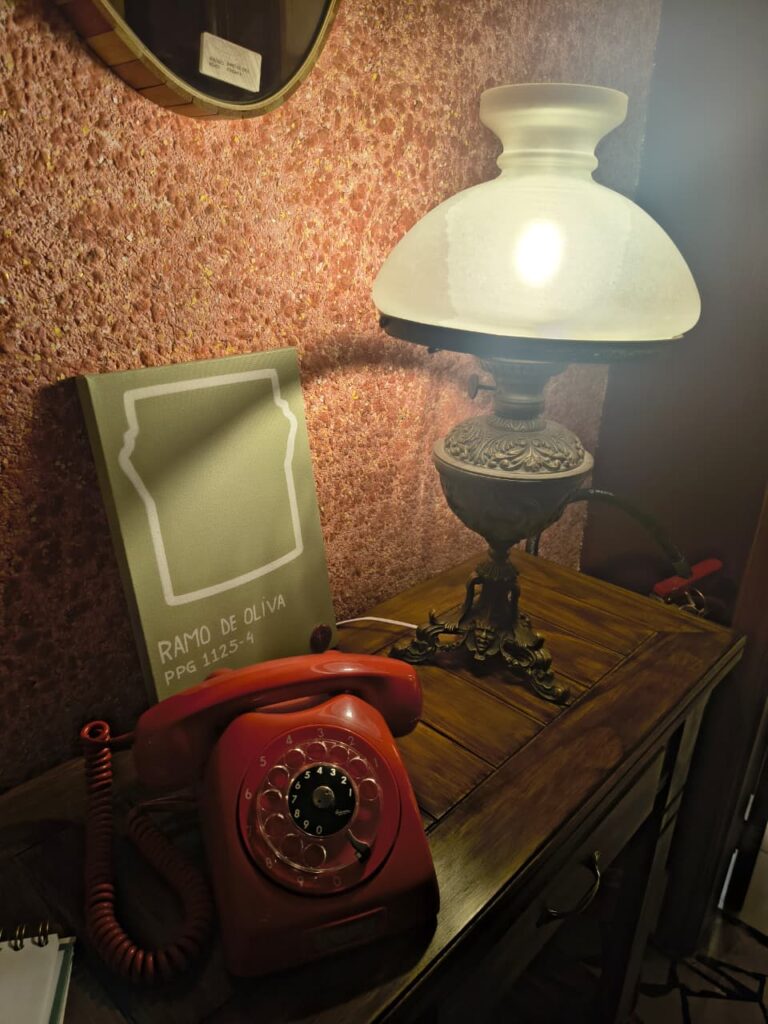 Aparador de madeira com abajur e telefone vermelho antigo